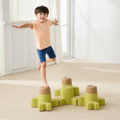 Menino a brincar em casa com brinquedo modular verde e castanho