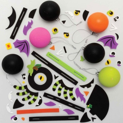 Bolas coloridas e pedaços recortados de papel com formas de olhos e asas sobre fundo branco