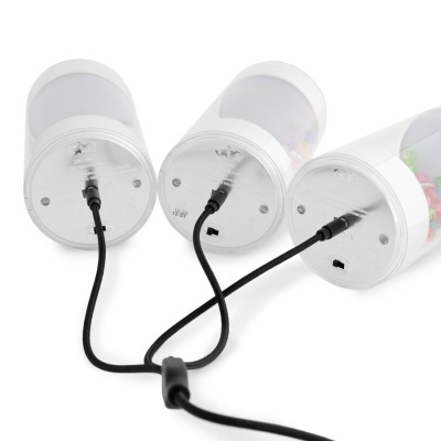 Três recipientes cilíndricos transparentes ligados por cabos pretos