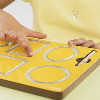 Tabuleiro educativo amarelo com formas geométricas recortadas em madeira clara