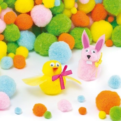 Figura decorativa em pompons de pato amarelo com laço rosa e coelho cor-de-rosa segurando uma cenoura, pompons coloridos ao redor