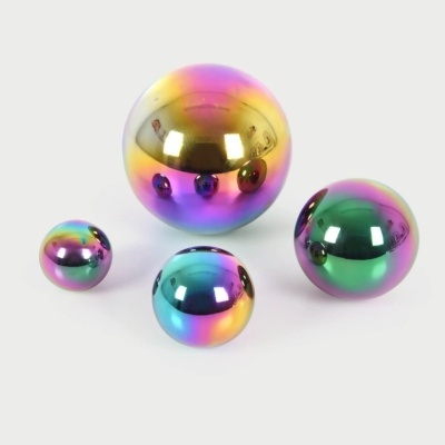 Quatro esferas metálicas iridescentes em várias cores sobre fundo branco