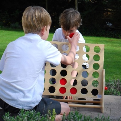 Crianças a jogar jogo quatro em linha ao ar livre