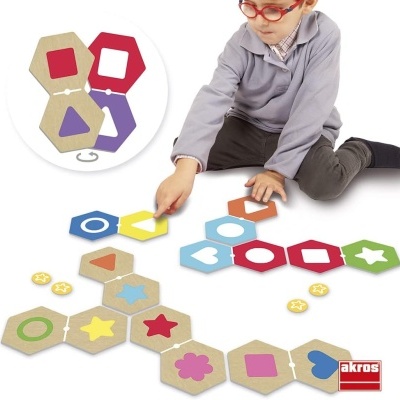 Criança a jogar com peças hexagonais coloridas com formas geométricas