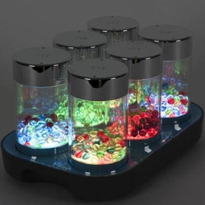 Frascos transparentes com tampas prateadas e pedras coloridas iluminadas em base preta