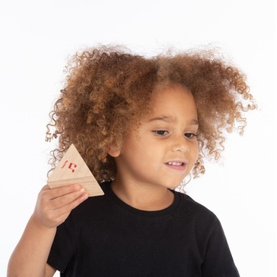 Criança com camisola preta segura brinquedo triangular de madeira com padrão vermelho