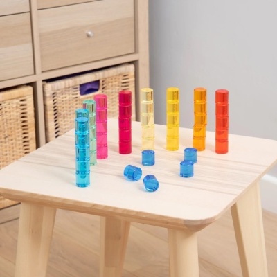 Jogo de pilares encaixáveis coloridos sobre mesa de madeira