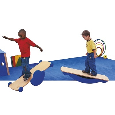 Crianças a usar brinquedos de equilíbrio em madeira e azul numa sala de atividades