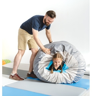 Pessoa a enrolar colchonete cinzento com criança dentro