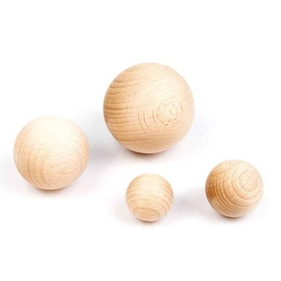 Quatro esferas de madeira de diferentes tamanhos sobre fundo branco