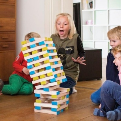 Crianças a jogar com blocos de madeira coloridos num chão de madeira