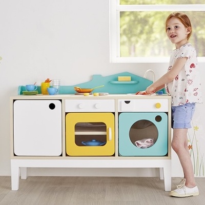 Cozinha de brincar infantil colorida com menina a brincar