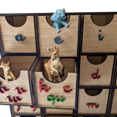 Armário de madeira com gavetas coloridas e miniaturas de animais