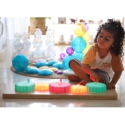 Criança brinca com brinquedo educativo colorido em base de madeira