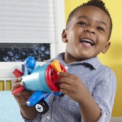 Criança a brincar com avião de brinquedo colorido