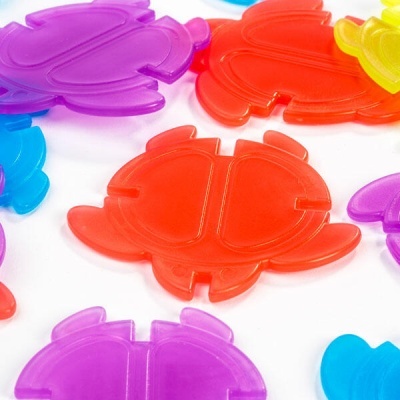 Peças plásticas coloridas em forma de caranguejo sobre fundo branco