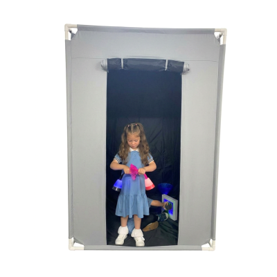 Cabine cinzenta com criança e objetos luminosos