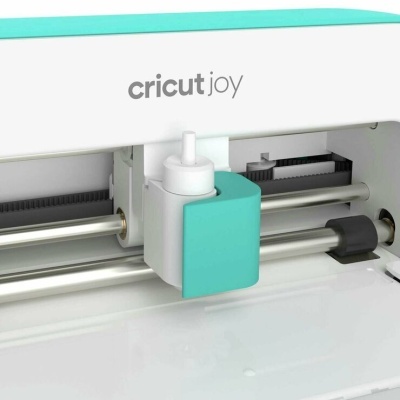 Máquina de corte Cricut Joy branca com detalhes azuis e componentes internos visíveis