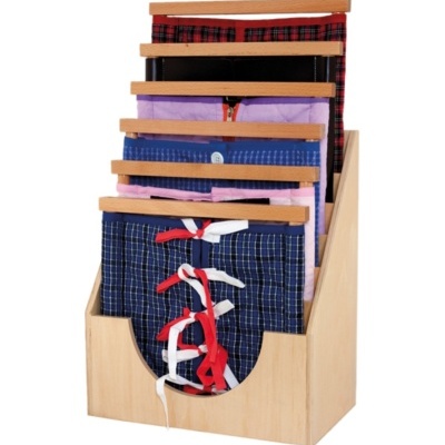 Conjunto de roupa pendurada em cabides de madeira num suporte de madeira clara