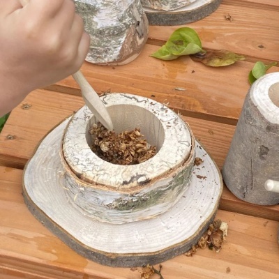 Recipiente rústico de madeira com granola numa mesa de madeira