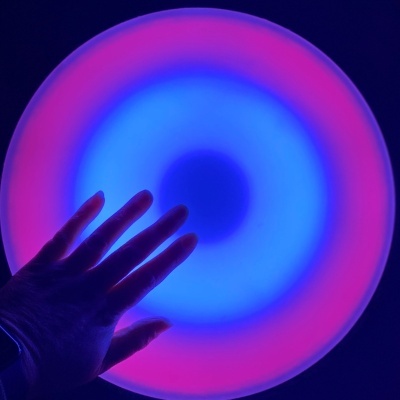 Mão junto a disco luminoso azul e rosa