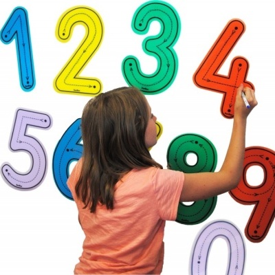 Criança a escrever em números adesivos coloridos