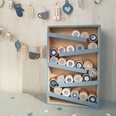 Organizador de madeira com rolos de carimbos decorativos em tons azuis e bege