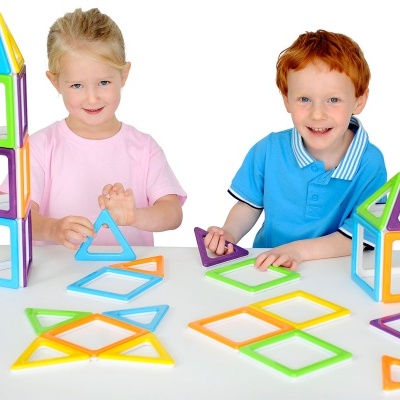 Crianças brincando com blocos magnéticos coloridos em formas geométricas