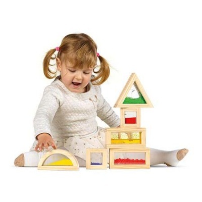 Menina a brincar com blocos de madeira com líquidos coloridos no interior