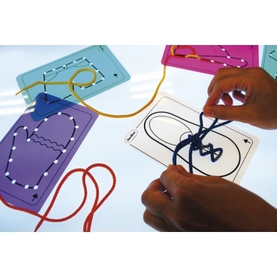 Placas coloridas com cadarços entrelaçados e mãos manipulando um cadarço azul