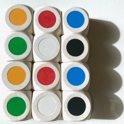 Doze dados brancos com pontos coloridos em amarelo, vermelho, azul, verde, branco e preto dispostos em quatro colunas de três linhas