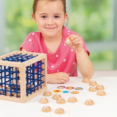 Menina a jogar com brinquedo de madeira e plástico de símbolos coloridos