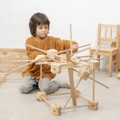 Criança a brincar com brinquedo de construção em madeira natural