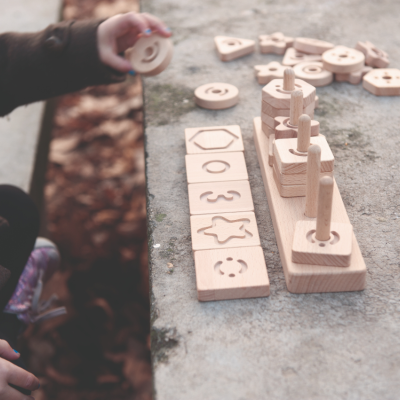 Brinquedo educativo em madeira com formas geométricas e símbolos