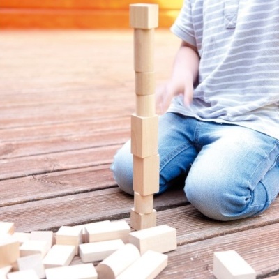 Criança a brincar com blocos de madeira num chão de madeira
