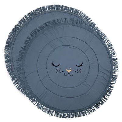 Tapete redondo azul com franjas e rosto de gato desenhado no centro