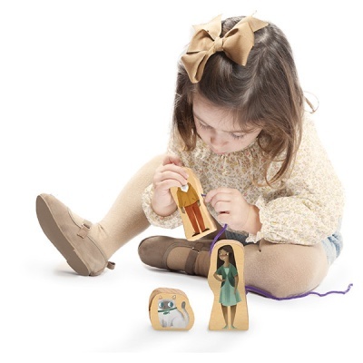 Criança brinca com bonecos de madeira coloridos.