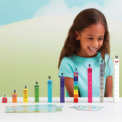 Criança a brincar com blocos coloridos numerados de 1 a 10 numa mesa branca