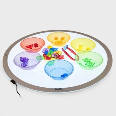 Prato redondo iluminado com seis tigelas coloridas e peças geométricas dentro