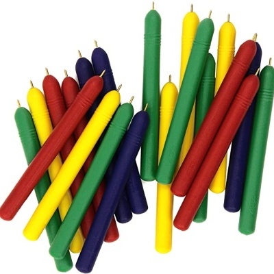 Velas coloridas vermelhas, verdes, amarelas e azuis com pavios sobre fundo branco