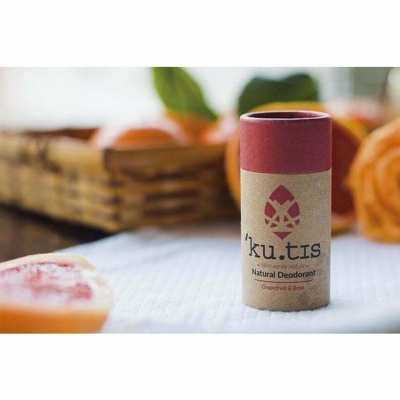 Desodorizante natural 'ku.tis' com embalagem em cartão cor de rosa e natural sobre tecido branco