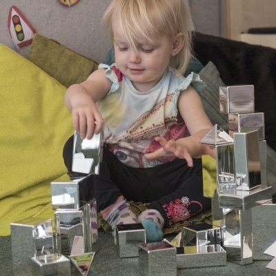 Criança a brincar com blocos metálicos prateados