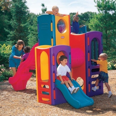 Parque infantil colorido com escorrega e escadaria, crianças a brincar ao ar livre
