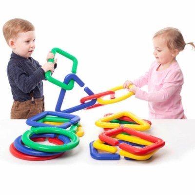 Duas crianças a brincar com brinquedos de encaixe coloridos em formas geométricas