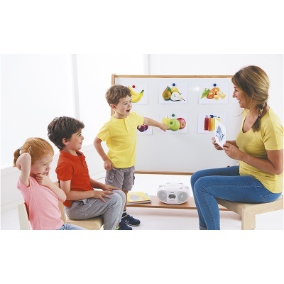 Mulher e três crianças sentados em sala com quadro branco e imagens de frutas e legumes