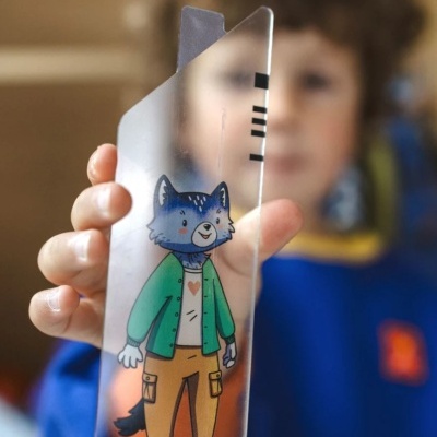 Régua transparente com ilustração de lobo azul vestindo casaco verde, camisa branca e calças castanhas