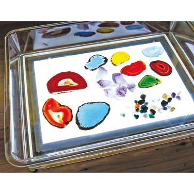 Bandeja transparente com várias pedras preciosas e minerais coloridos
