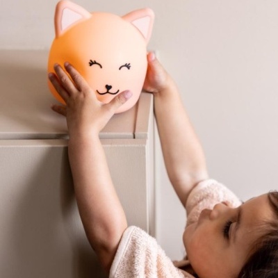 Lâmpada abajur formato cabeça de gato cor de pêssego com orelhas cor-de-rosa.