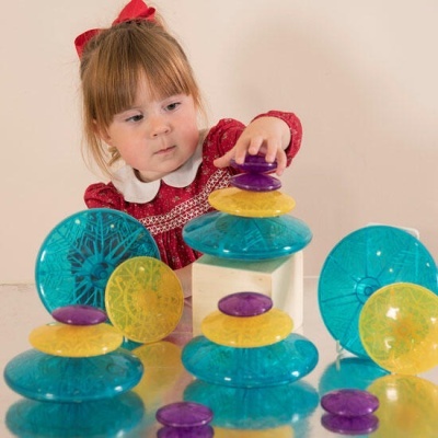 Criança a brincar com discos plásticos coloridos