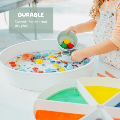 Jogo de mesa com tabuleiro circular branco e bolinhas coloridas na água, criança a brincar e roda de cores na frente